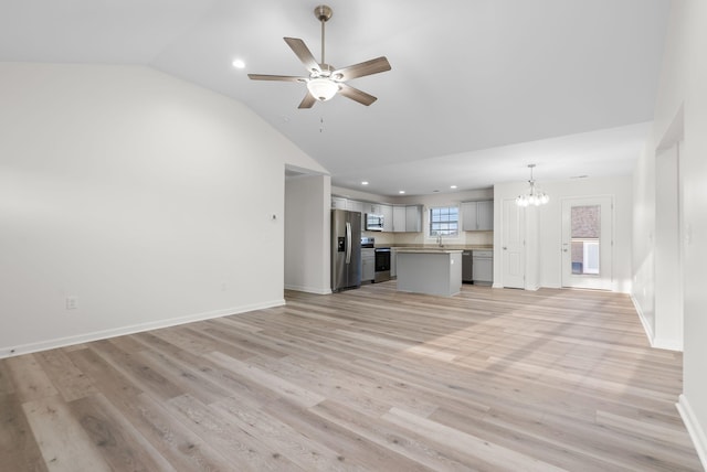 unfurnished living room with sink, high vaulted ceiling, ceiling fan with notable chandelier, and light wood-type flooring