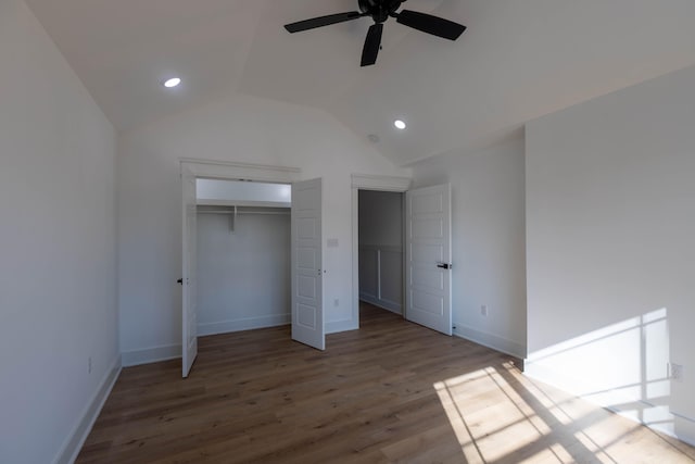 unfurnished bedroom featuring a closet, ceiling fan, wood-type flooring, and lofted ceiling