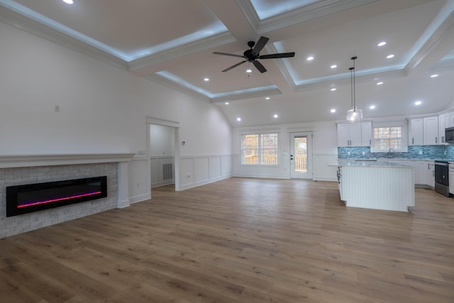 unfurnished living room with light hardwood / wood-style floors, ornamental molding, and ceiling fan