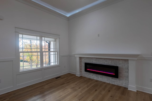 unfurnished living room featuring crown molding and hardwood / wood-style flooring