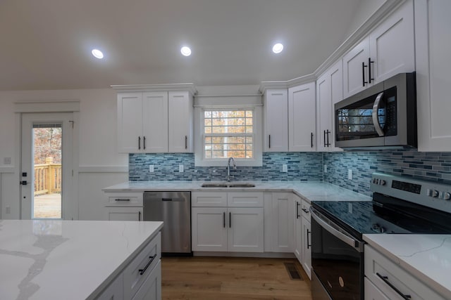 kitchen with white cabinetry, stainless steel appliances, and plenty of natural light