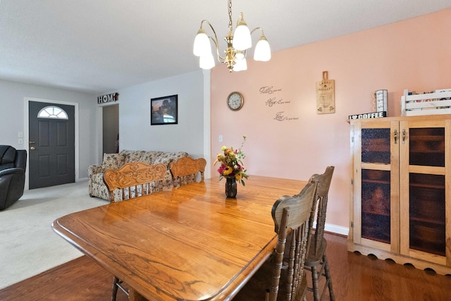 carpeted dining room with a notable chandelier