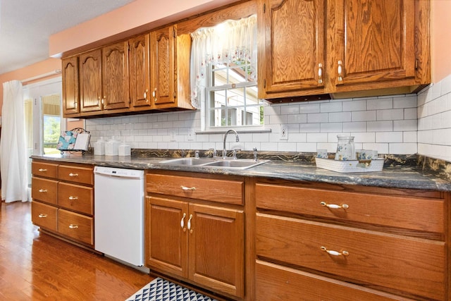 kitchen with sink, decorative backsplash, dishwasher, and hardwood / wood-style floors