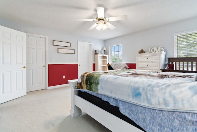 carpeted bedroom with a textured ceiling and ceiling fan