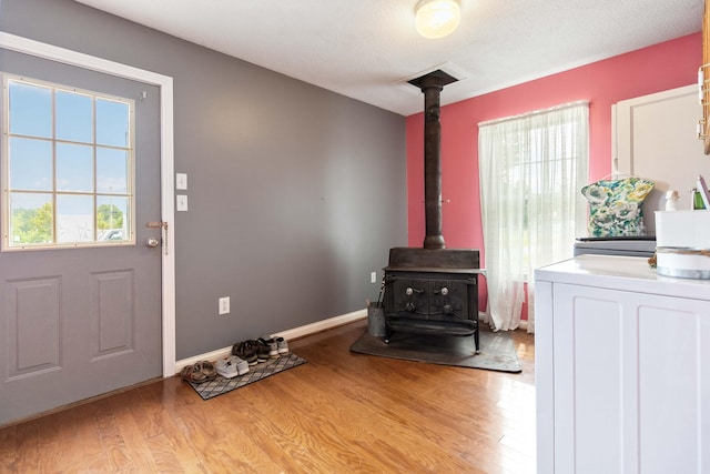 interior space featuring washer / clothes dryer, light wood-type flooring, and a wood stove