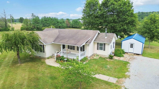 single story home with a storage unit, a porch, and a front lawn