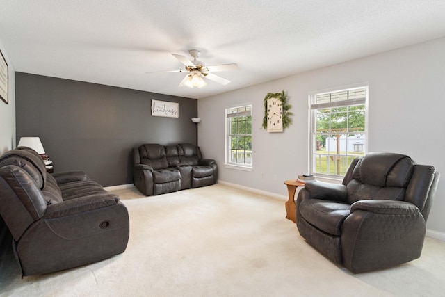 carpeted living room with a textured ceiling, a healthy amount of sunlight, and ceiling fan