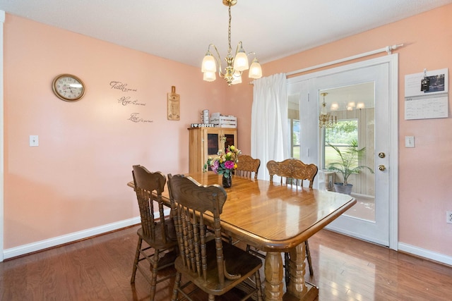 dining space with an inviting chandelier and hardwood / wood-style floors