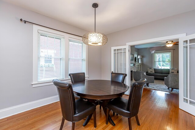 dining space with light wood-type flooring and ceiling fan