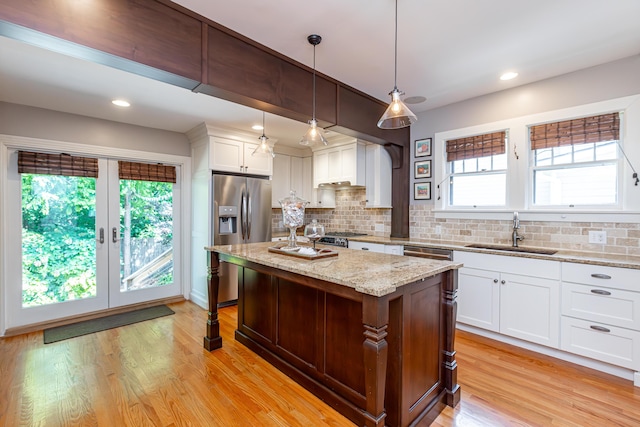 kitchen featuring plenty of natural light, a sink, white cabinets, and stainless steel appliances