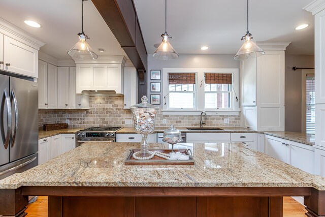 kitchen with appliances with stainless steel finishes, light hardwood / wood-style flooring, tasteful backsplash, and white cabinets