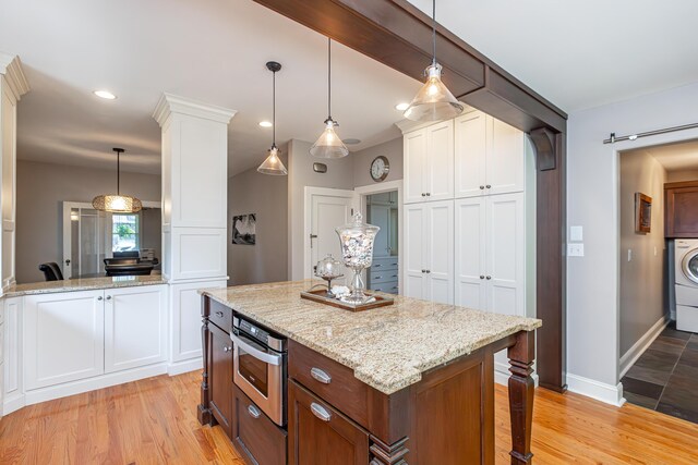 kitchen featuring white cabinets, pendant lighting, and light hardwood / wood-style floors