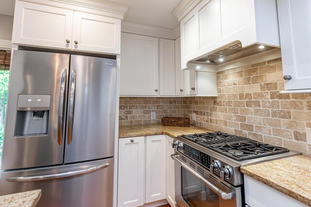 kitchen with white cabinets, stainless steel appliances, backsplash, and light stone counters