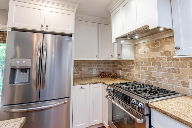 kitchen with light stone counters, decorative backsplash, white cabinets, and stainless steel appliances