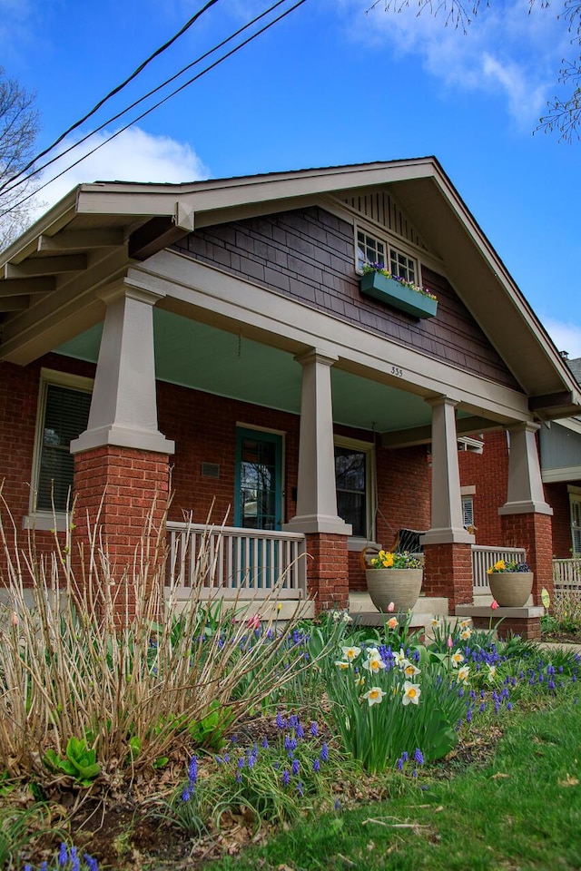 craftsman-style house with a porch and brick siding