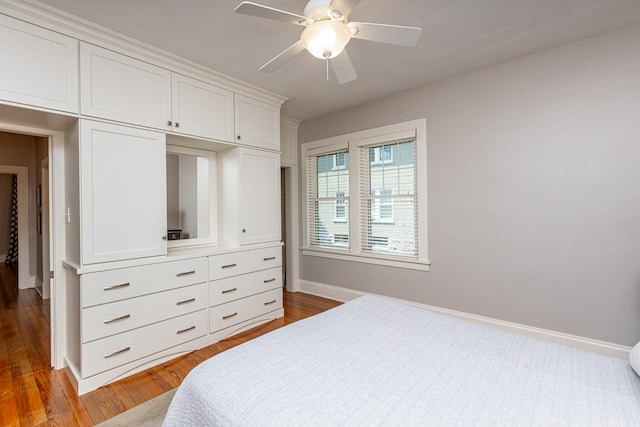 bedroom featuring baseboards, dark wood-style flooring, and ceiling fan