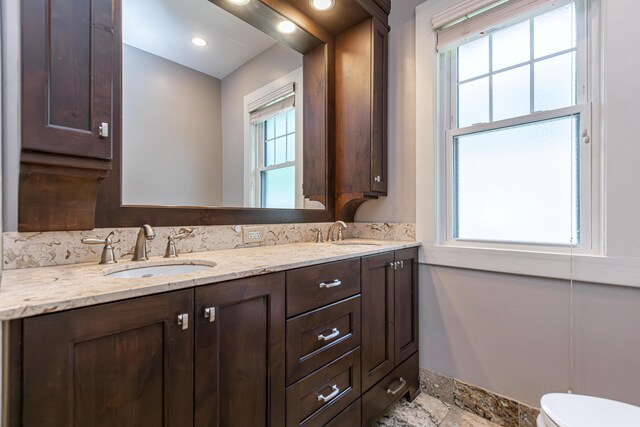 bathroom featuring dual vanity, tile patterned floors, toilet, and a wealth of natural light