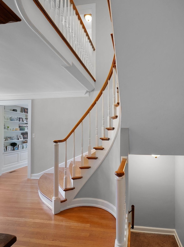 stairway with built in features and wood-type flooring