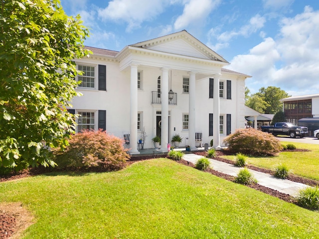 greek revival house featuring a front yard