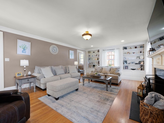 living room with a fireplace, built in shelves, ornamental molding, and wood-type flooring