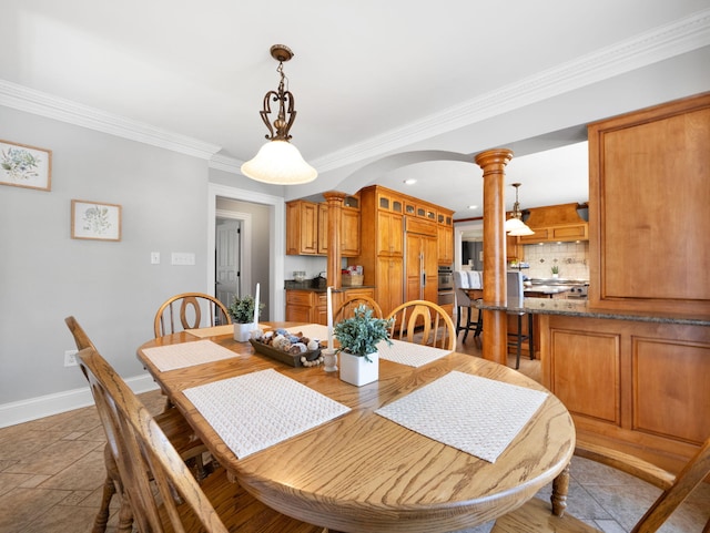 dining room with crown molding and ornate columns