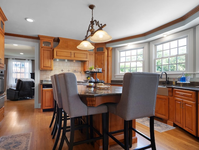 dining room featuring light hardwood / wood-style floors, ornamental molding, and sink