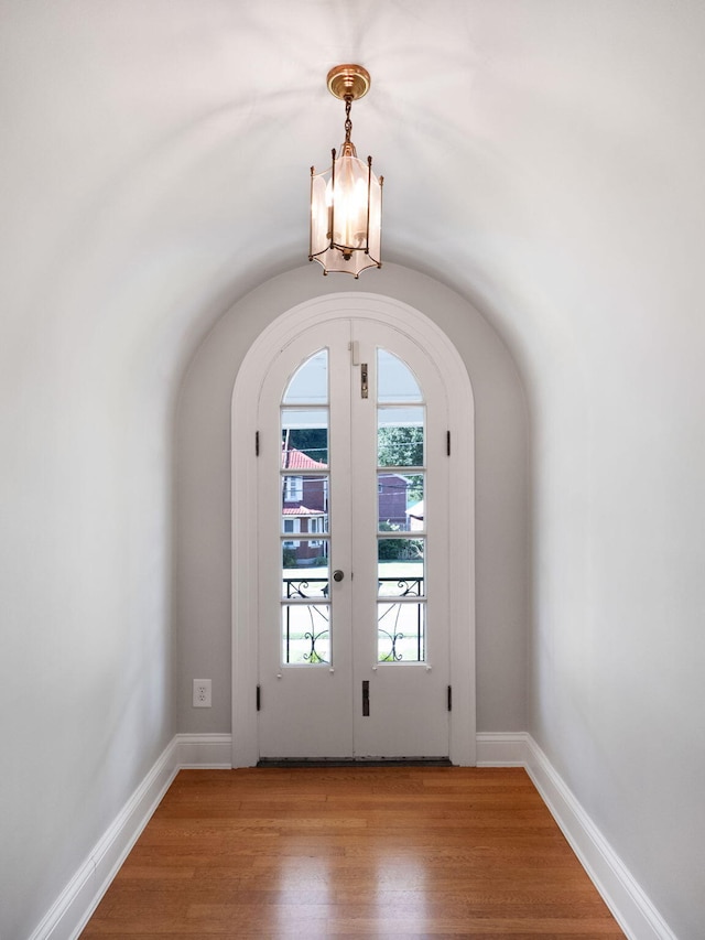 doorway to outside featuring french doors, light hardwood / wood-style flooring, and a chandelier