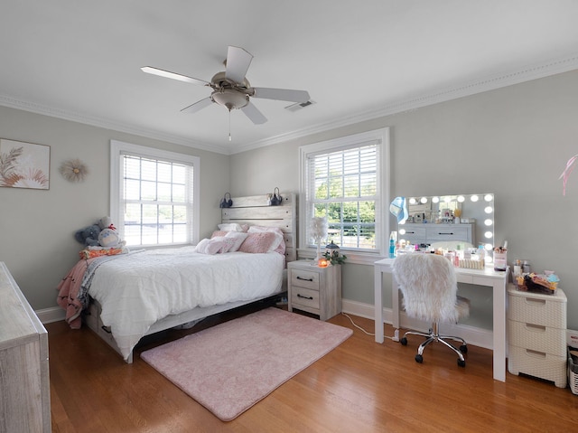 bedroom with hardwood / wood-style floors, ceiling fan, and crown molding