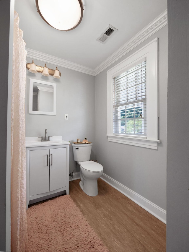 bathroom featuring vanity, hardwood / wood-style floors, toilet, and ornamental molding