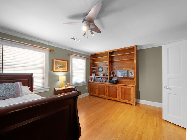 bedroom with ceiling fan, crown molding, and light hardwood / wood-style floors