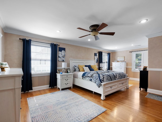 bedroom featuring ceiling fan, crown molding, light wood-type flooring, and multiple windows