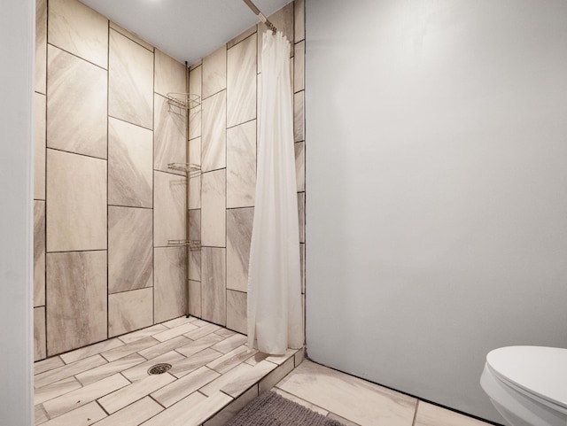 bathroom featuring a shower with shower curtain and toilet