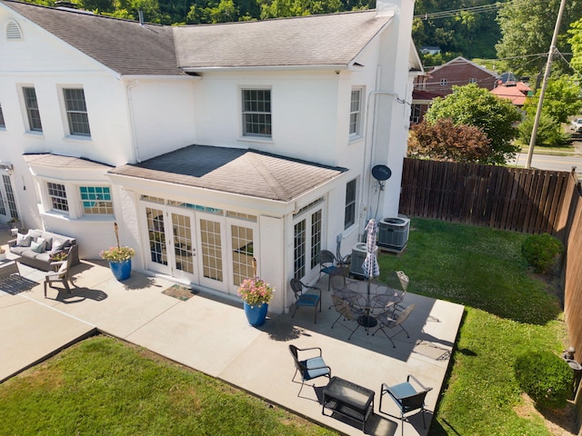 rear view of house featuring central AC unit, french doors, a lawn, and an outdoor living space