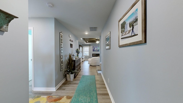 hallway with light hardwood / wood-style floors