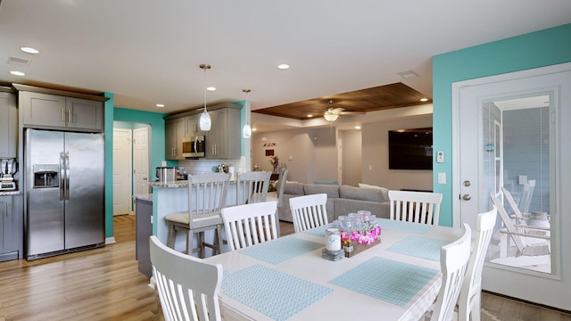 dining space with ceiling fan and light hardwood / wood-style floors