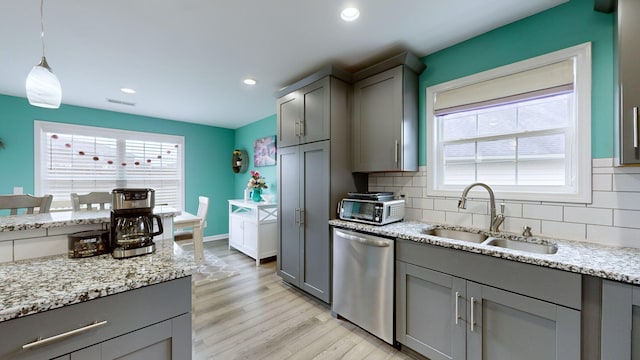 kitchen featuring dishwasher, hanging light fixtures, sink, tasteful backsplash, and gray cabinetry