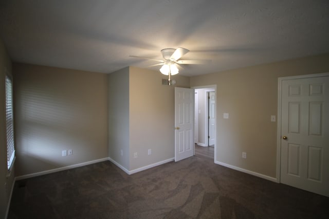 unfurnished bedroom featuring dark colored carpet and ceiling fan