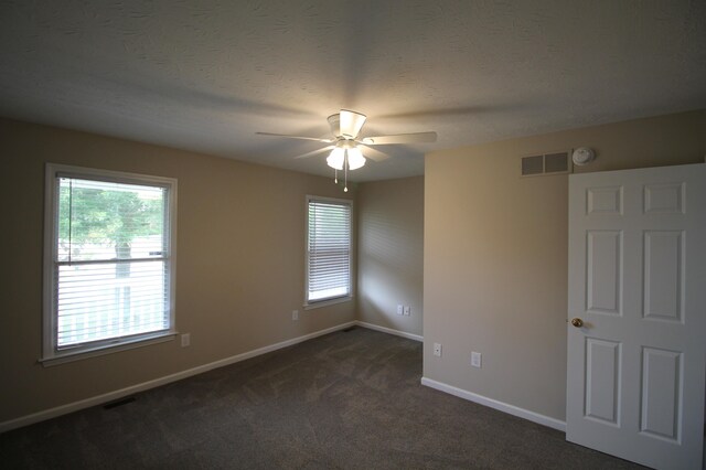 empty room featuring dark carpet and ceiling fan