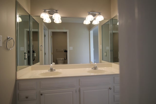 bathroom featuring toilet and double vanity