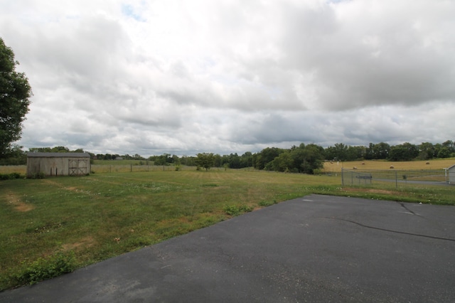 view of yard with an outbuilding and a rural view