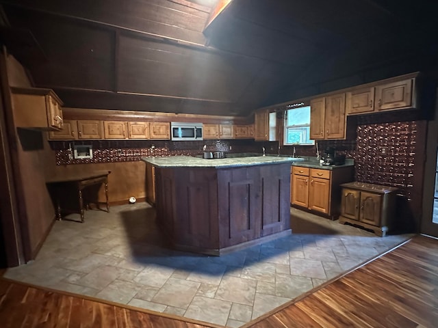 kitchen featuring hardwood / wood-style floors, a center island, and tasteful backsplash