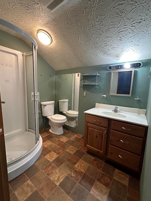 bathroom featuring walk in shower, vanity, toilet, lofted ceiling, and a textured ceiling