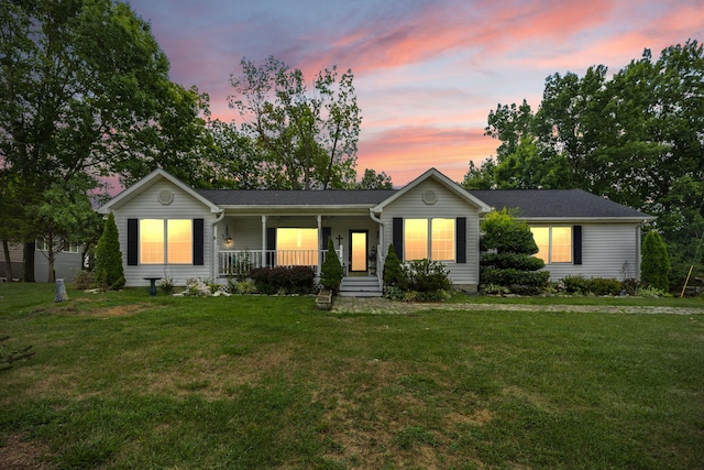 single story home with covered porch and a lawn