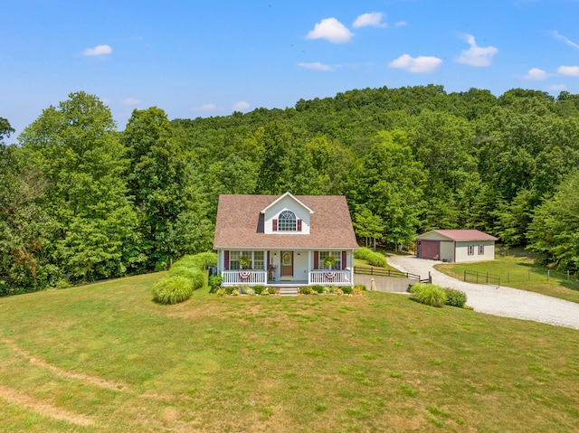 view of front of property with a garage, covered porch, an outbuilding, and a front yard