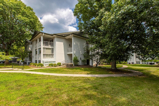 view of building exterior with central AC and a lawn