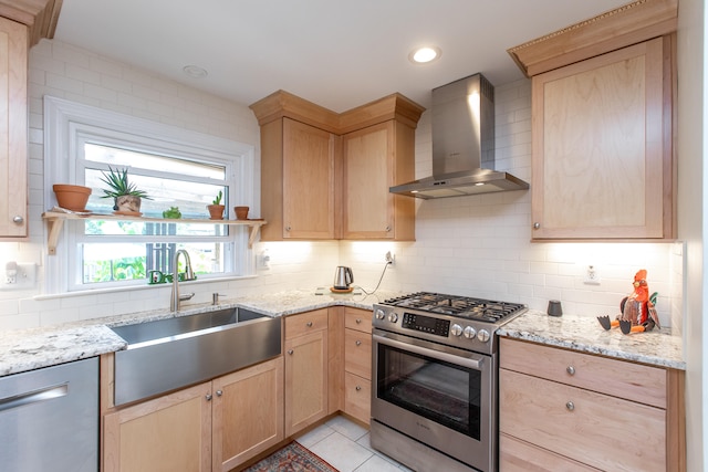 kitchen with appliances with stainless steel finishes, tasteful backsplash, and wall chimney range hood