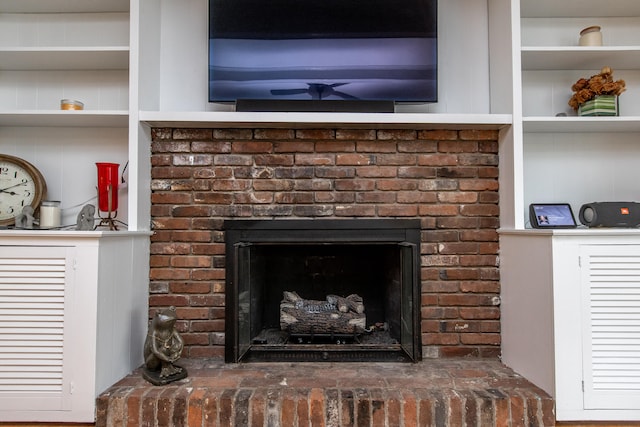 room details with built in shelves and a brick fireplace