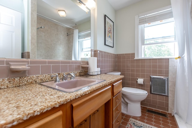 bathroom featuring tasteful backsplash, tile walls, toilet, tile patterned floors, and vanity