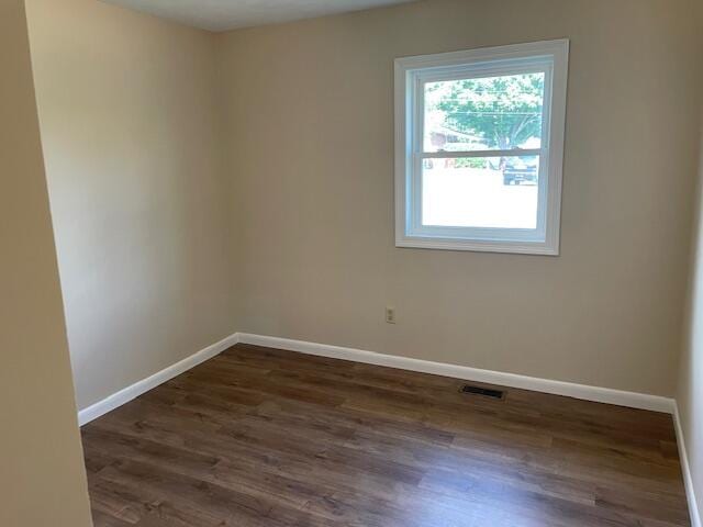 spare room with dark hardwood / wood-style flooring