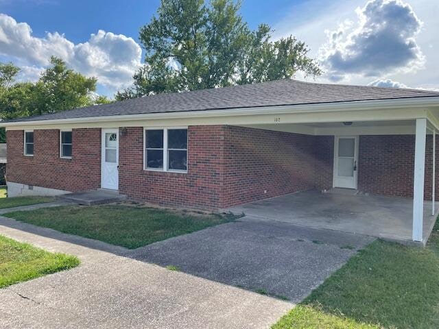 view of front of property featuring a carport and a front lawn